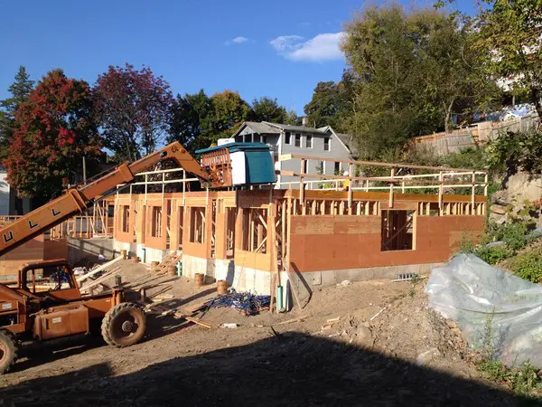 House under construction with autumn trees.