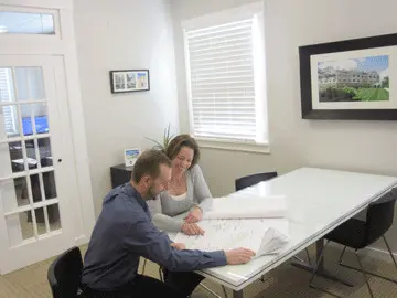 Colleagues discussing blueprints at table