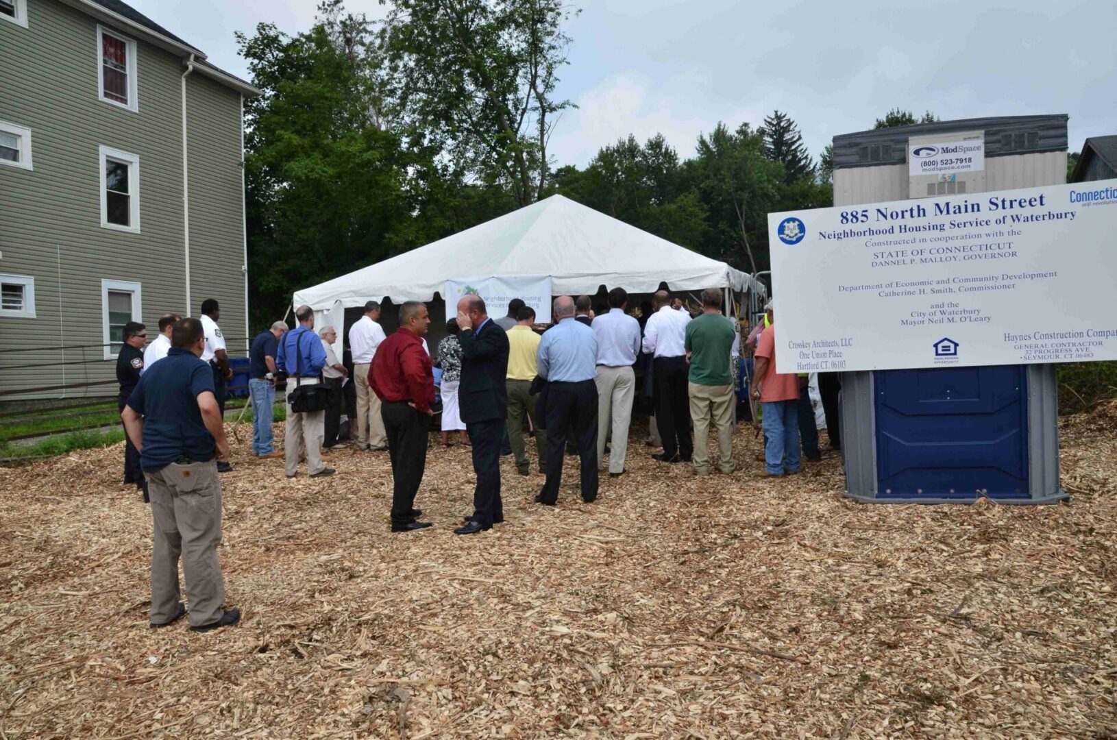 Group standing on wood chips outside tent