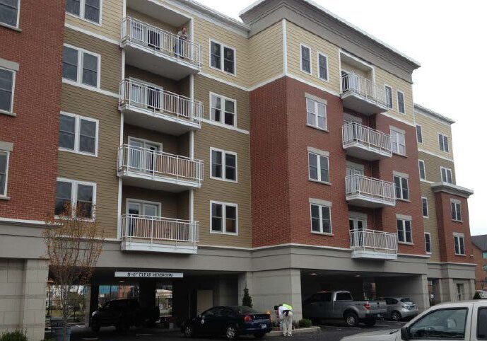 Urban apartment complex with cars below.